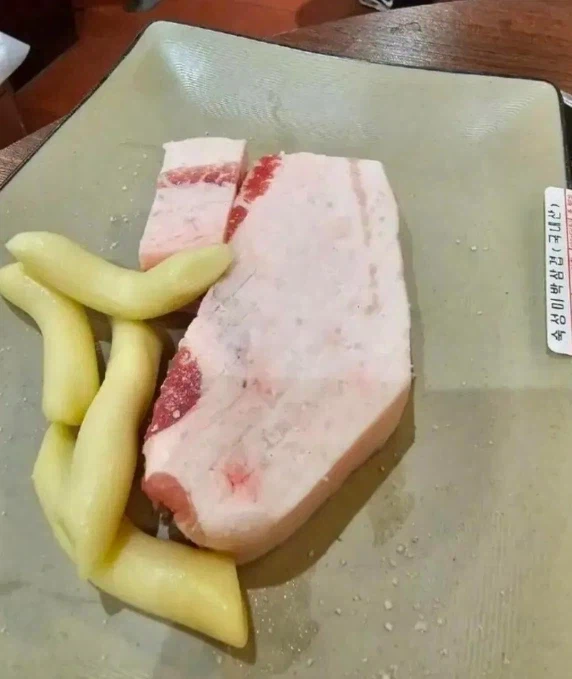 Korean community post, image 2: The 'gourmet' cut arrives: it's basically a solid slab of pork fat with barely a sliver of meat.