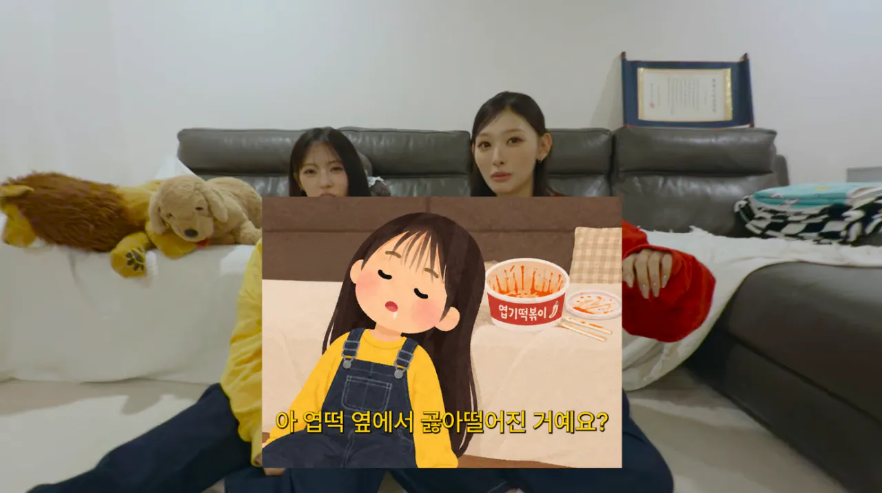 Korean community post, image 5: A cute cartoon overlay jokes: 'So she just passed out right next to the spicy rice cakes?'
